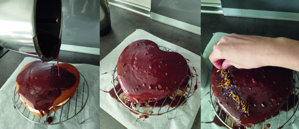Cobertura de chocolate líquido siendo vertida sobre la tarta colocada en una rejilla, con decoración de pétalos de flores secas añadida a mano.
